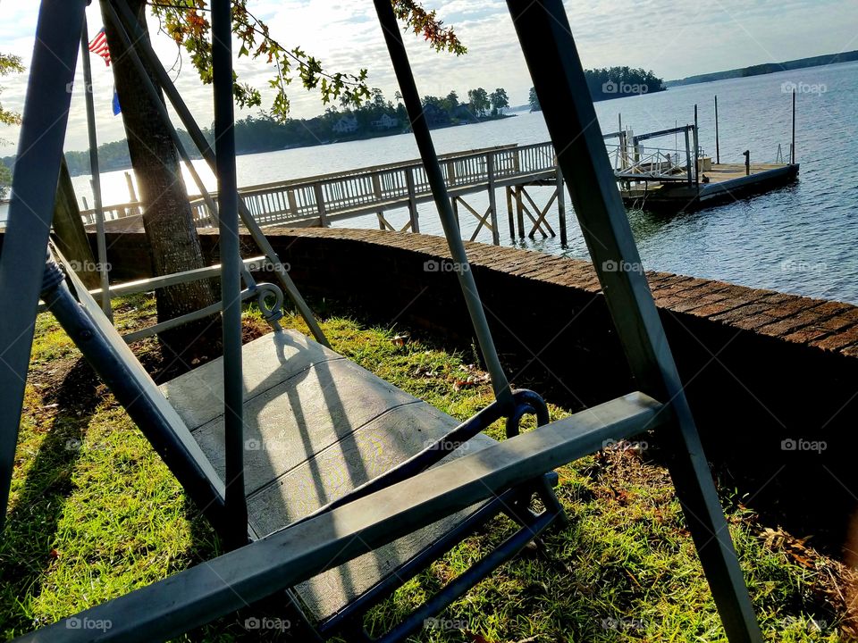 Swinging chair overlooking a lake and dock