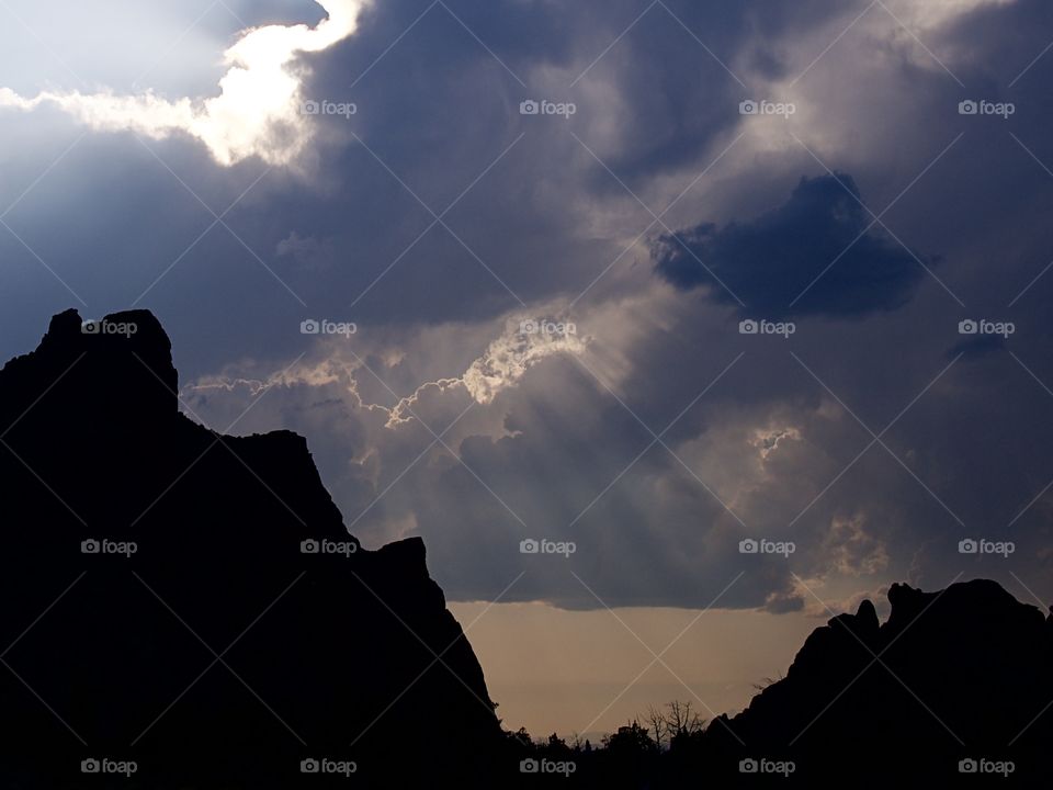 Beautiful sun rays break through the clouds after an evening summer rain storm at Smith Rocks in Central Oregon. 