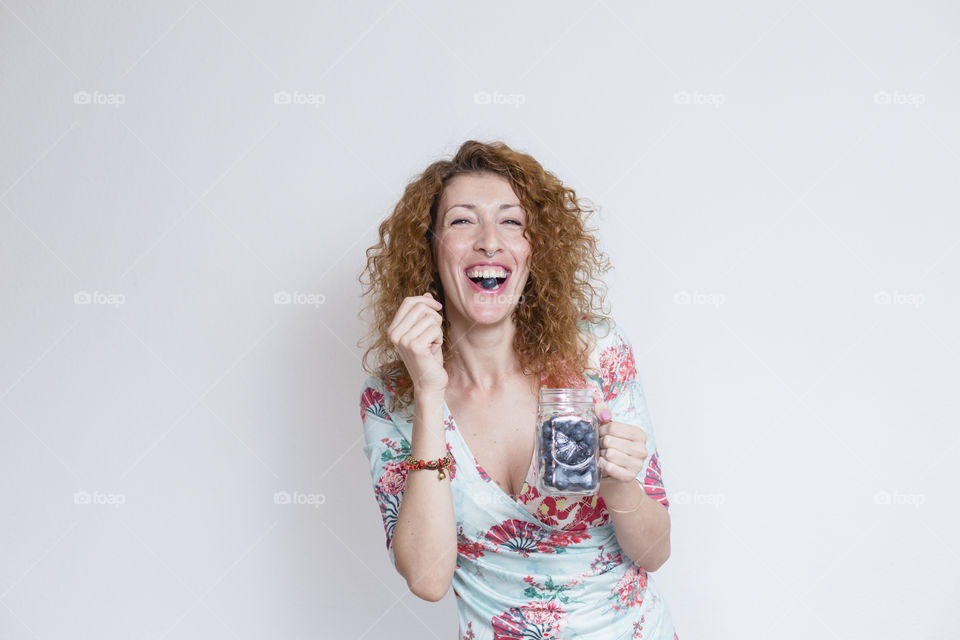 young Beautiful woman eating blueberries