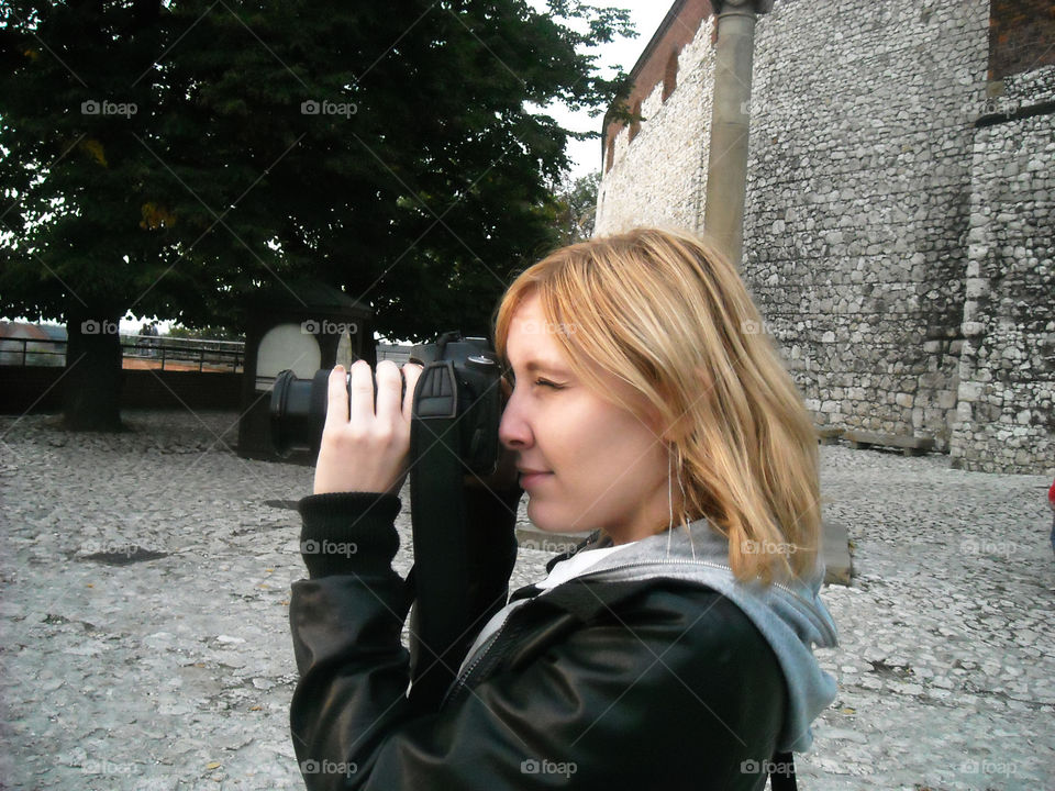 Young woman taking photograph with camera