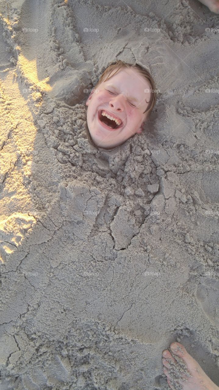 My son laughing as we bury him in the sand at Myrtle Beach SC