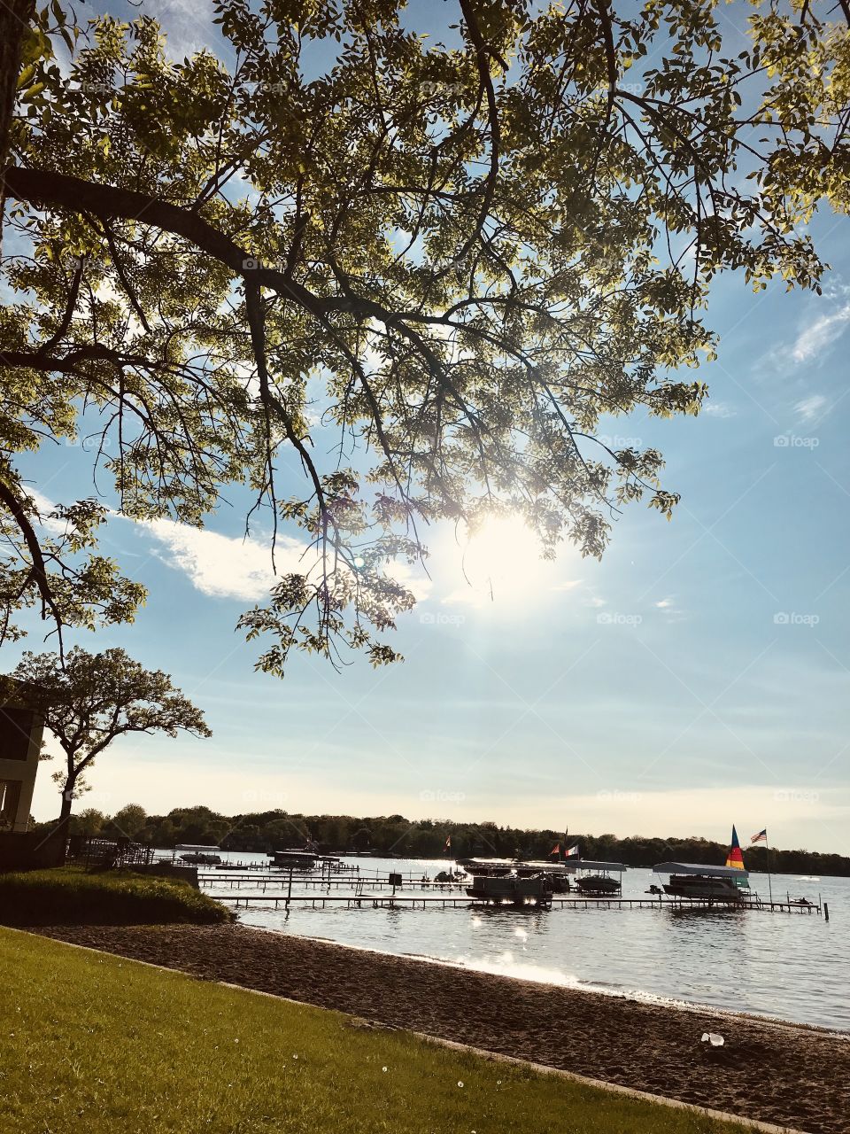 Gorgeous photo of sunny afternoon looking over beautiful lake and dock area full of boats! 