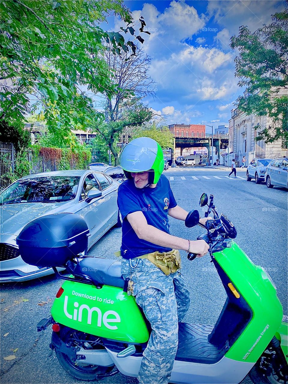 Enthusiastic LIME electro scooter rider Timothy Trespas turns around on his moped to begin the long journey back to LIC, Queens, NY from Bushwick, Bklyn at Broadway and Myrtle Avenue which is where this picture was taken. 2021. Hypnotic Productions 