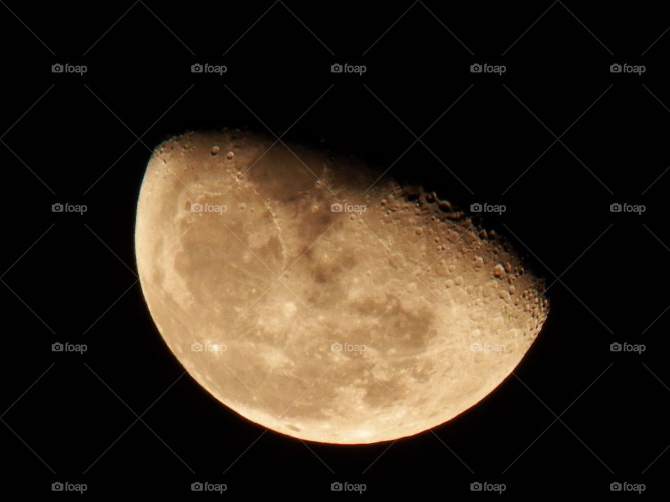 Closeup moon at night on black background. A golden half moon