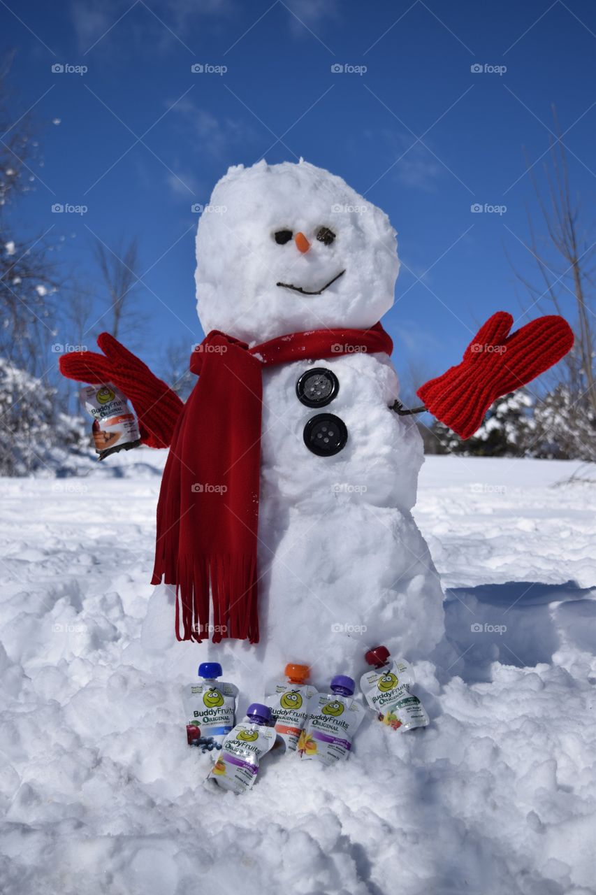 A friendly snowman sharing Buddy Fruits pouches.