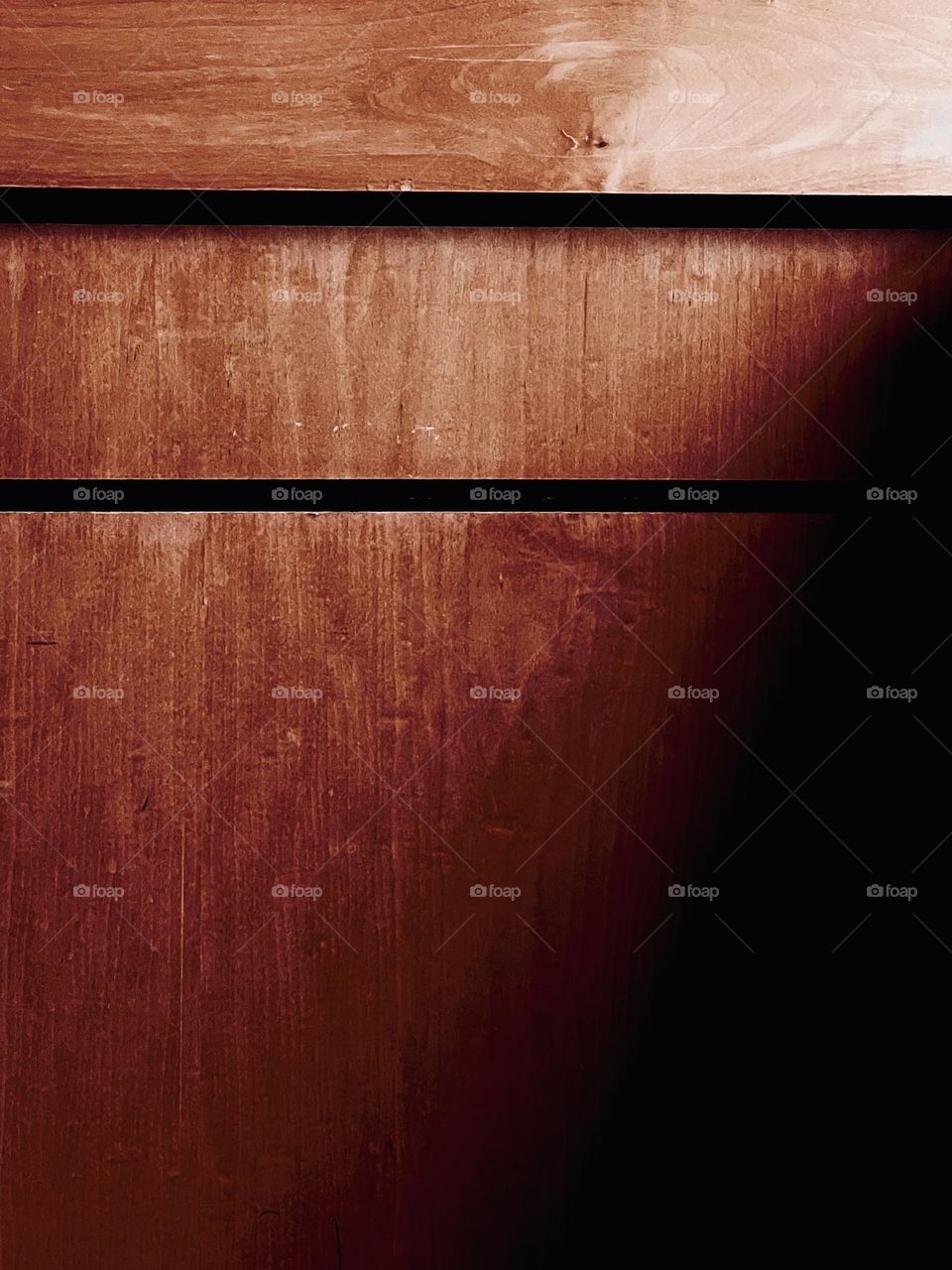 Wooden wall panels with a shadow cast over them.