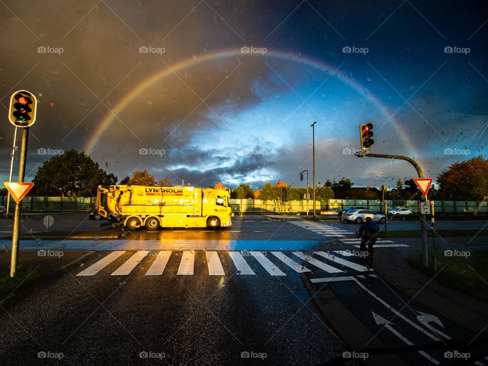 sunny autumn morning in the city at the crossroads with a rainbow in the sky