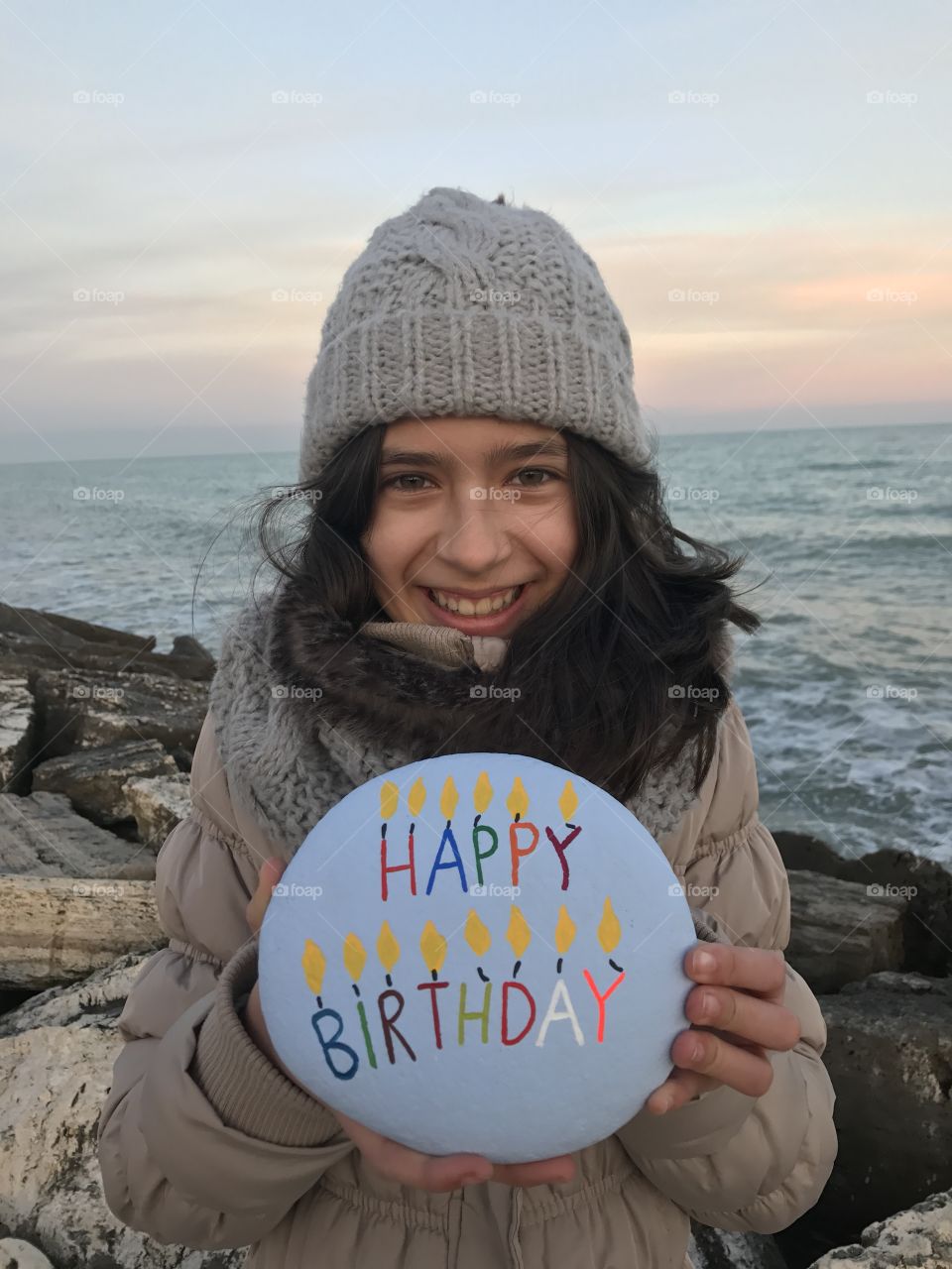 Girl showing pebble stone happy birthday word