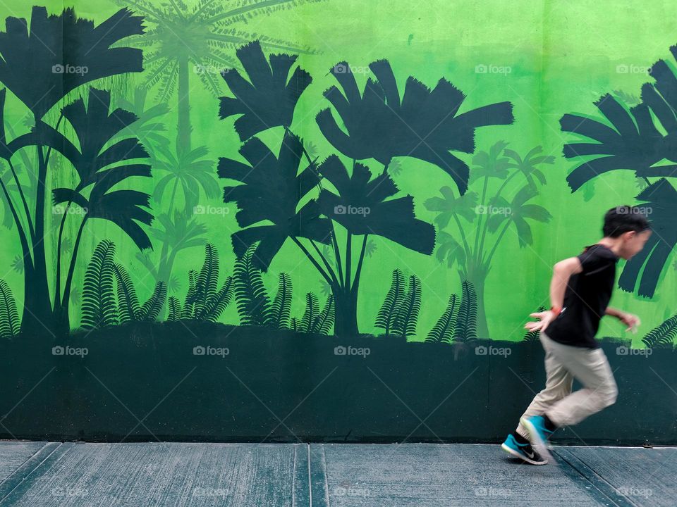 A boy running infront of street art