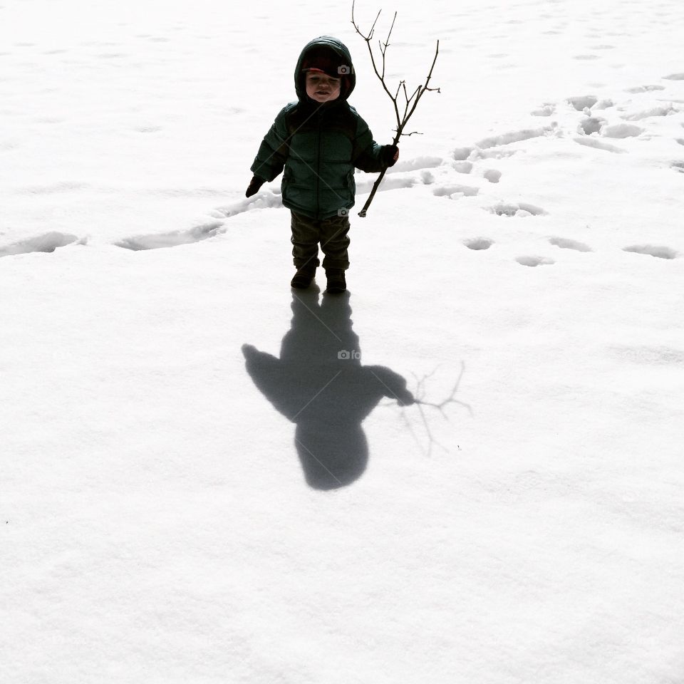 Here I'll stand . A young boy amongst white snow