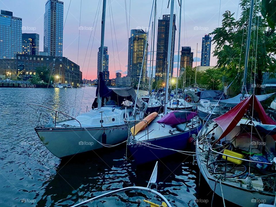 Boats are tied to the shore here at “Newtown Creek” in LIC, Queens by the “Pulaski Bridge”. This adds to the special allure that this place has already with spectacular views all around the boroughs including “Manhattan”. 2023. Hypnotic Productions