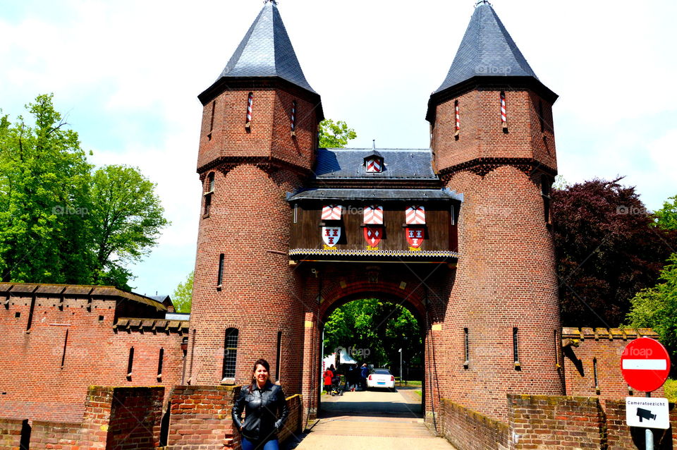 Female tourist against entrance gate of the Kasteel de Haar Castle