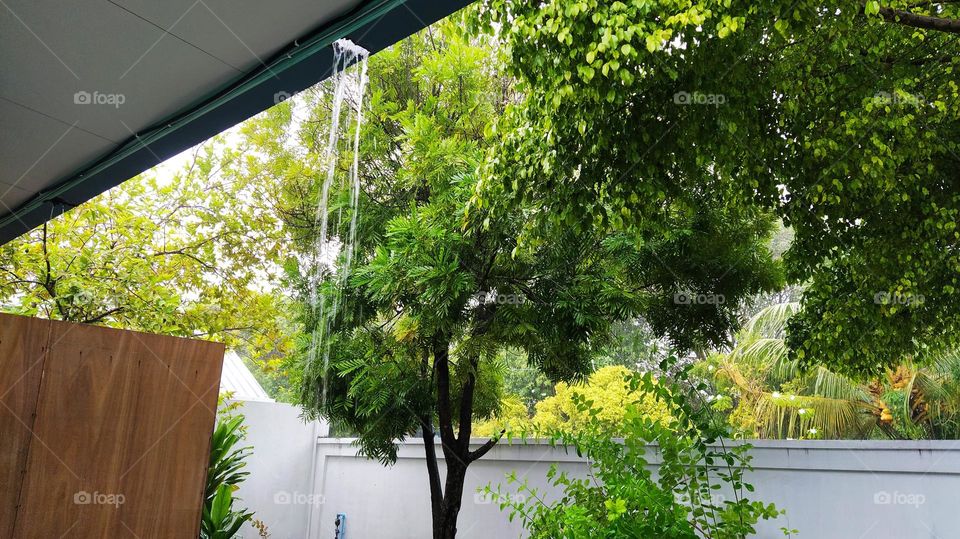 Collection of rain water is falling from the roof on a rainy day