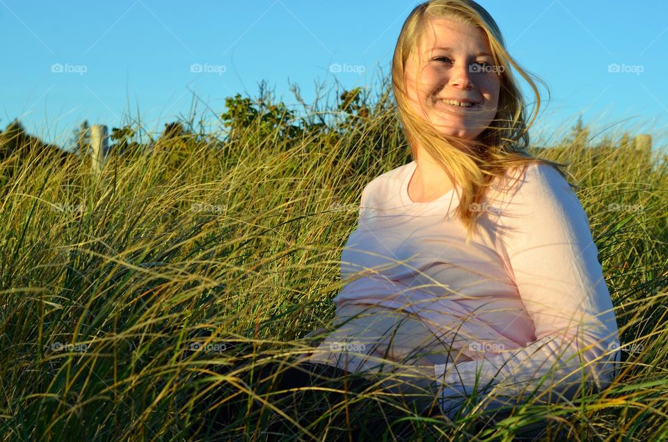 Smiling woman sitting on grassy field