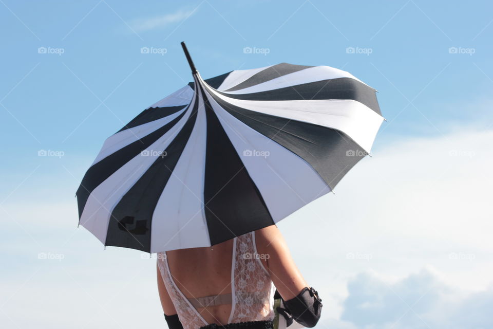Black and white umbrella . Woman on stilts at Cannes film festival 