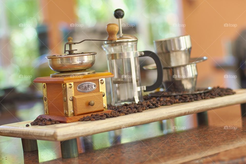 Still life with a vintage coffee grinder, coffee beans and other objects for the preparation of a good coffee.