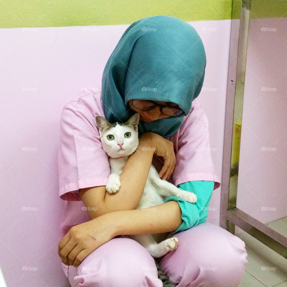 A nervous cat holding by nurse at the vet
