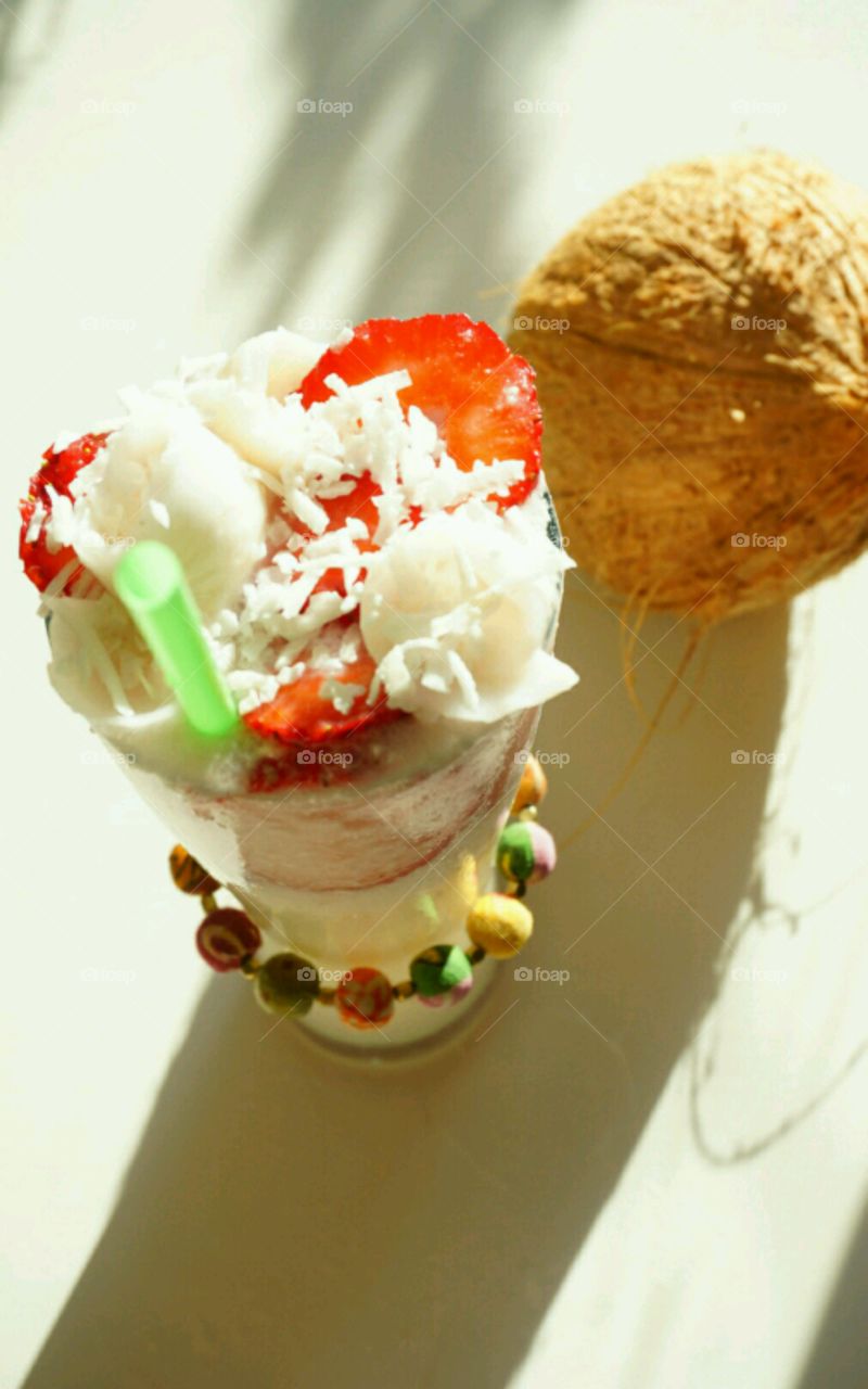 Fresh Fruit smoothie - Young Coconut smoothie topped with slices of strawberries and diced coconut meat