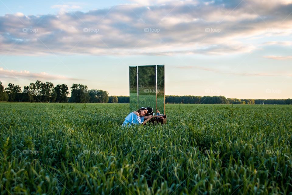 Portrait of young woman in the field during the sunrise 