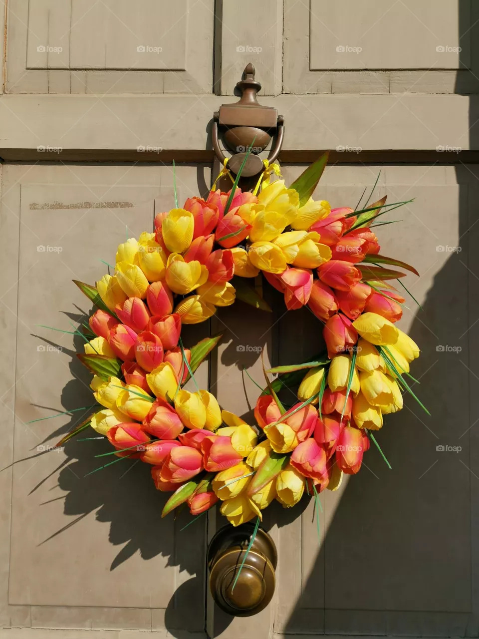 Easter time. Easter wreath on the door. 
Doors decorating. Tulips derogation. Springtime.