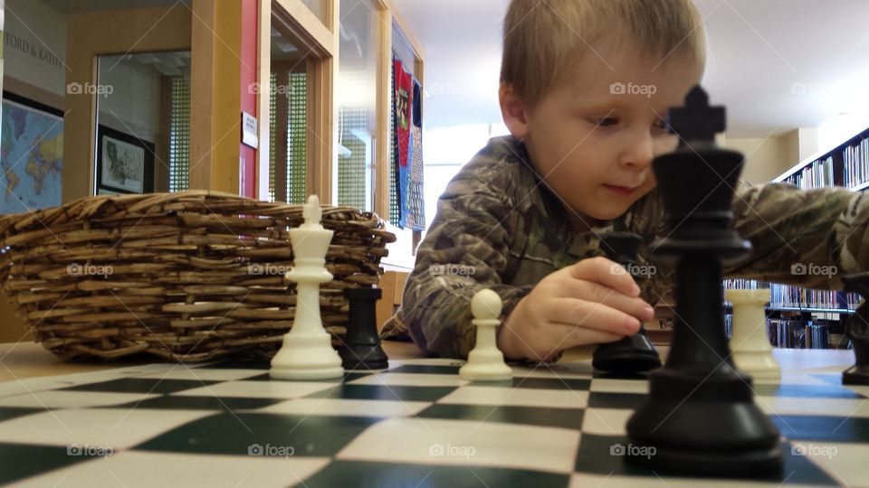 boy playing with chess pieces