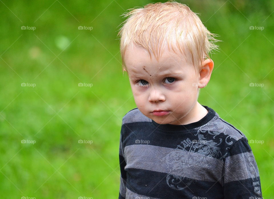 Cute and serious boy in the rain