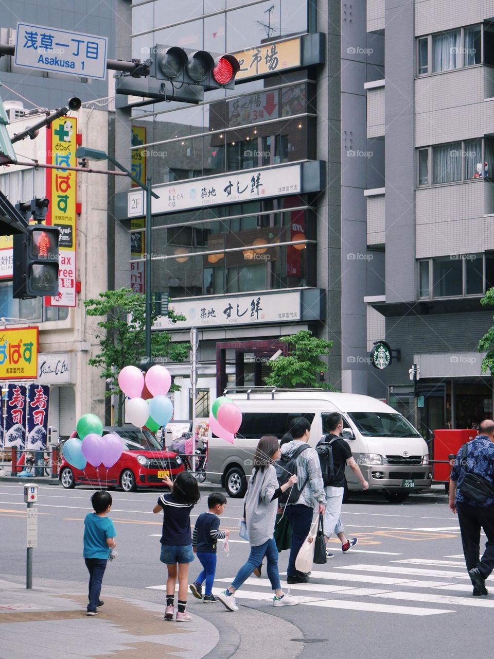 Family with baloons walking around the city
