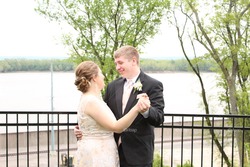 A loving couple dance outside in beautiful scenery.