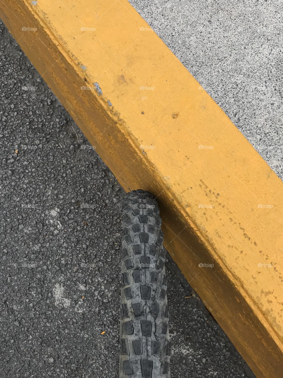 Bike wheel an yellow curb