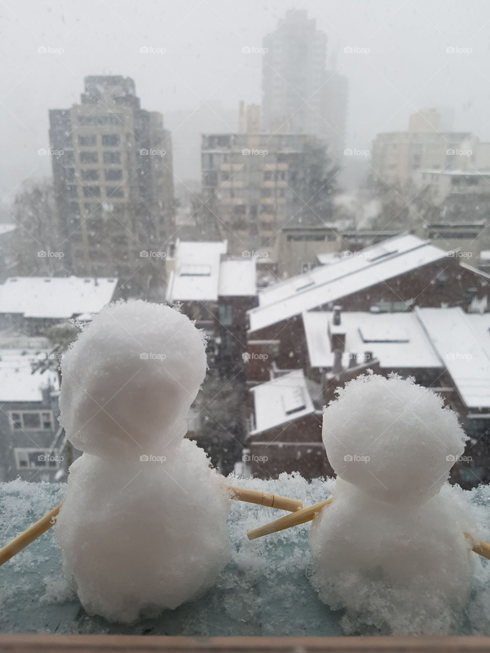snow men on an apartment window ledge