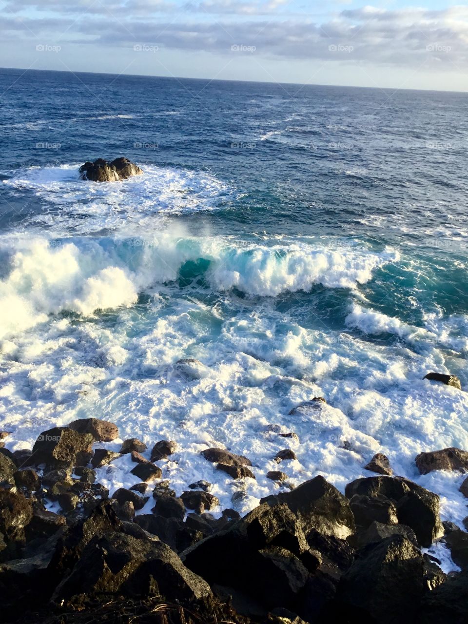 Wave headed to the lava rock shore