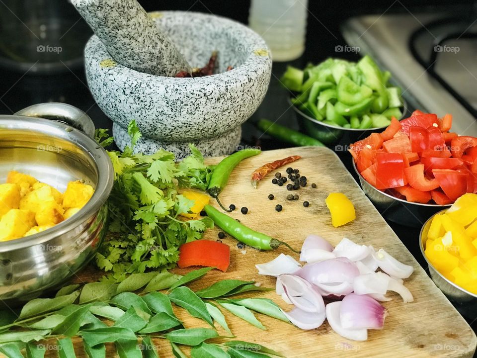 Indian hand mixer and other vegetables on chopping board 