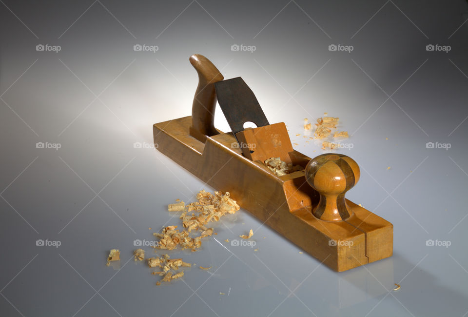 Close-up of an old wooden planer with wood chips on the foreground and background.