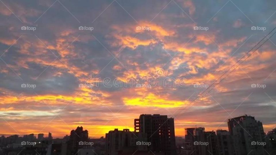 Even when the sky is filled with clouds the sun still shines above. Building view