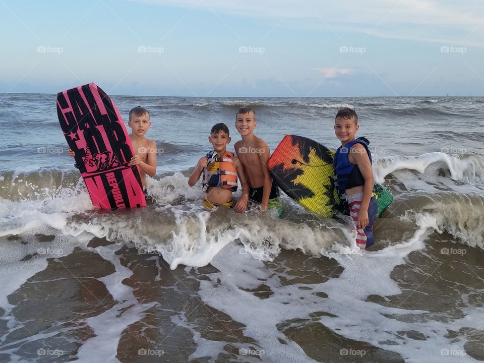 a group of boys having fun at the beach in the Gulf of Mexico near sea Rim Park in Texas in May 2018 United States of America