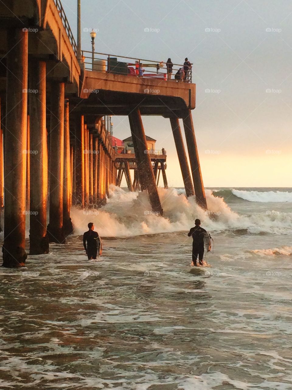 Spring Sunset. Two surfers heading in at sunset.