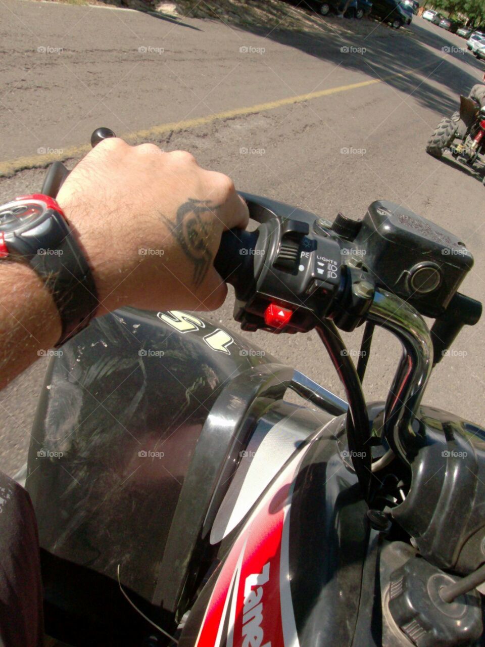Driving a quad bike. The driver's hand is observed.