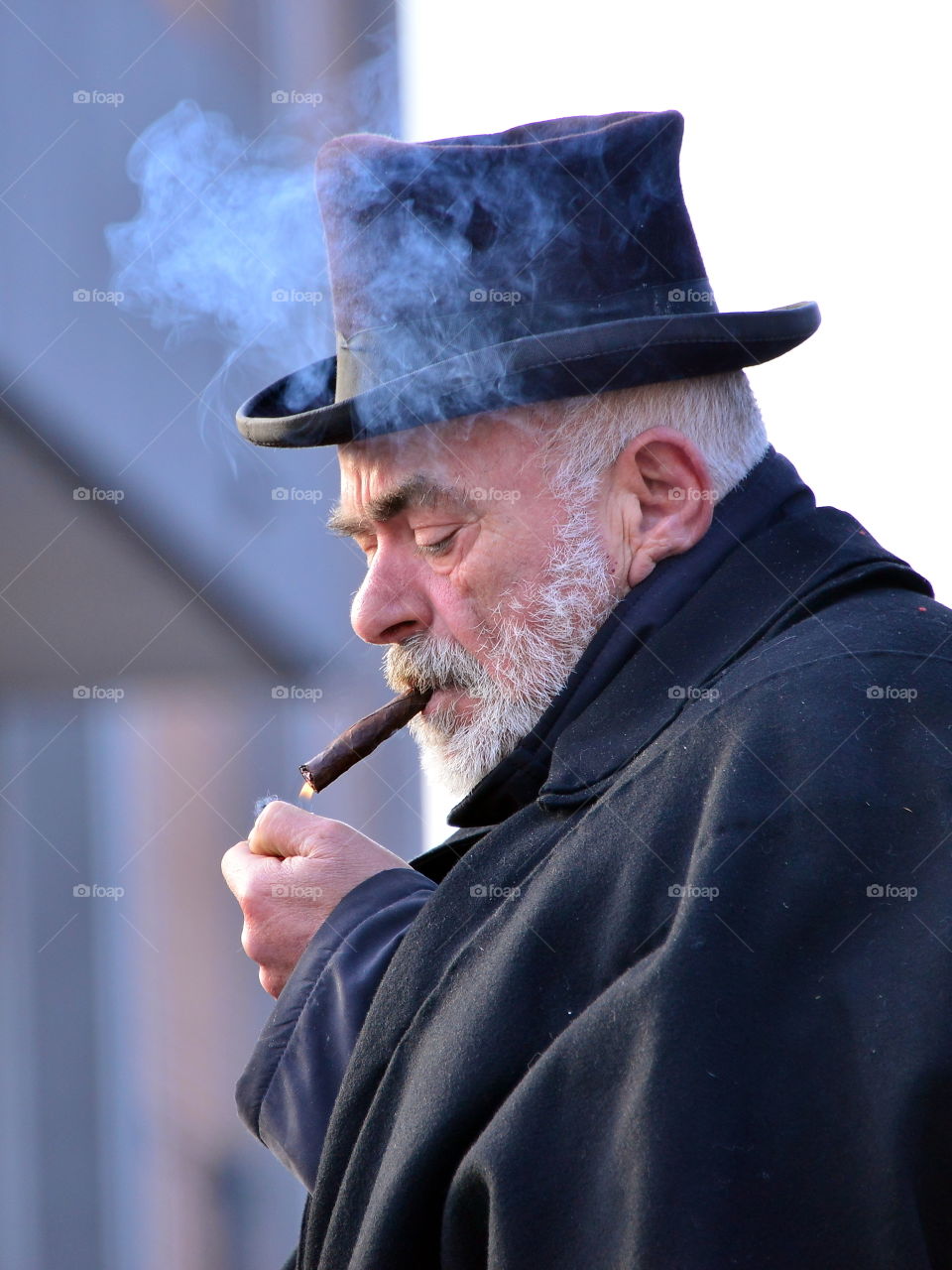 a man in a hat smokes a cigar