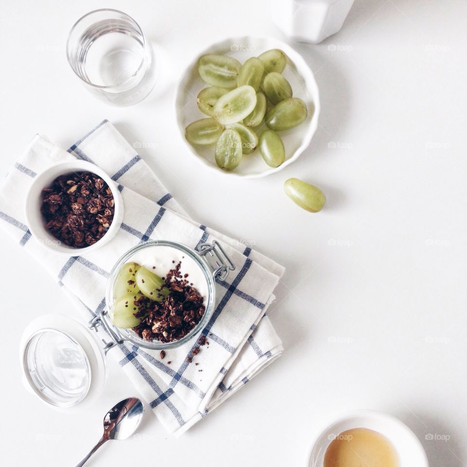 Healthy breakfast with yogurt, granola and green grapes.