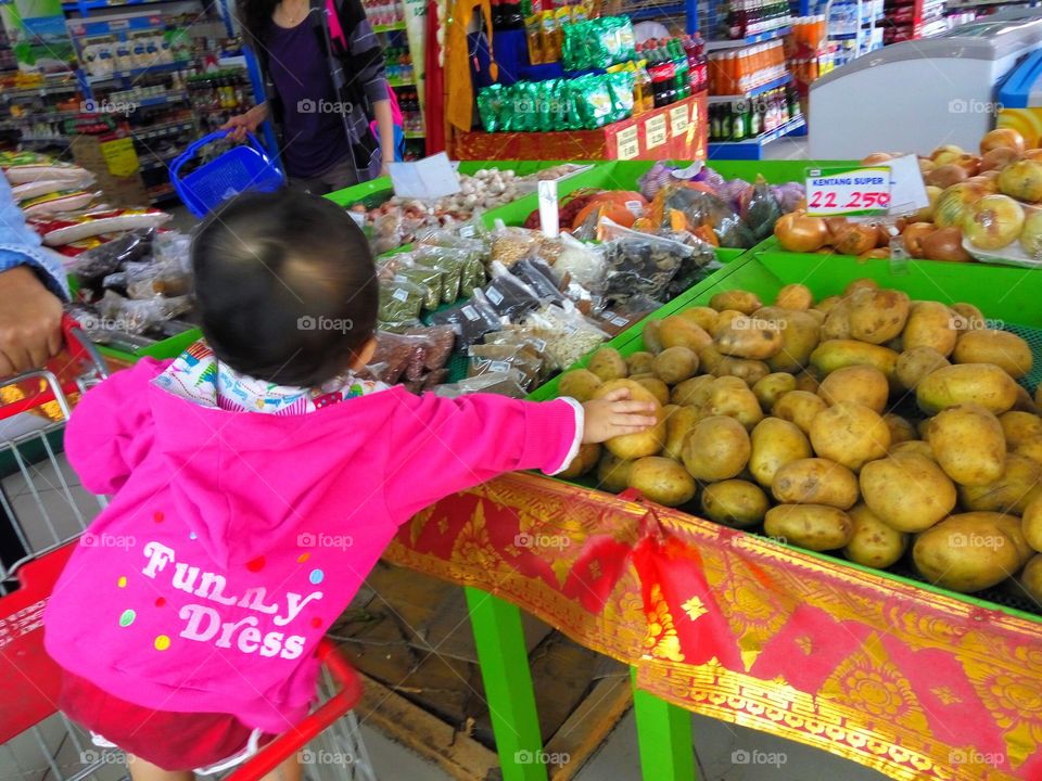 Baby learn how to shopping at the grocery store.