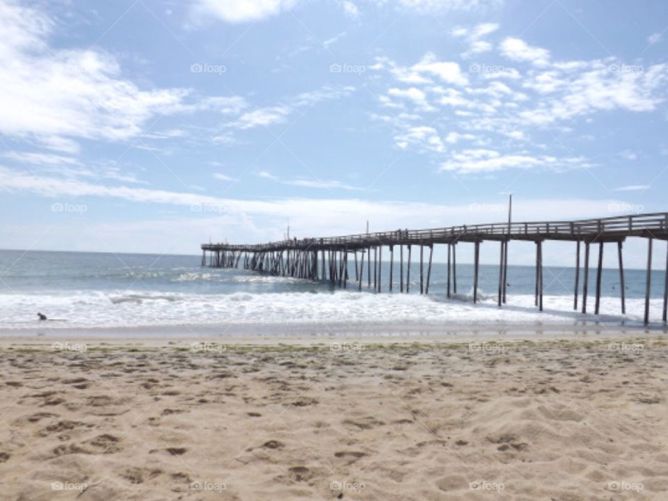 pier with clouds and waves coming in