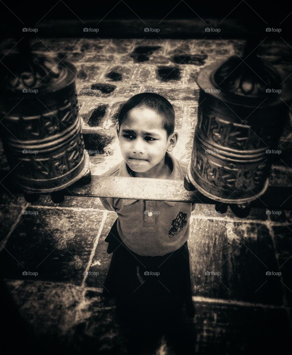 A Buddhist novice observing the prayer wheel.