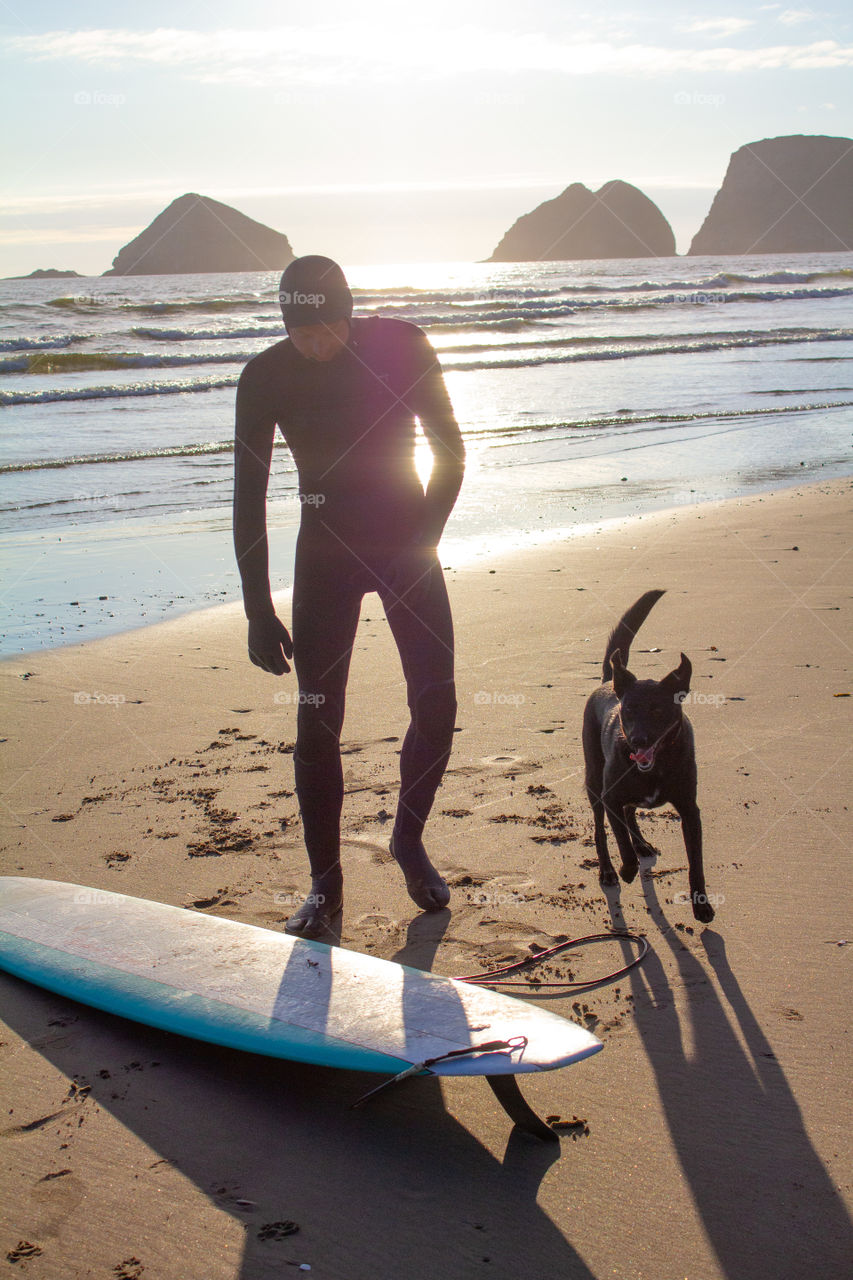 Sunset surf with a very excited dog in the summer on the Oregon coast beach 