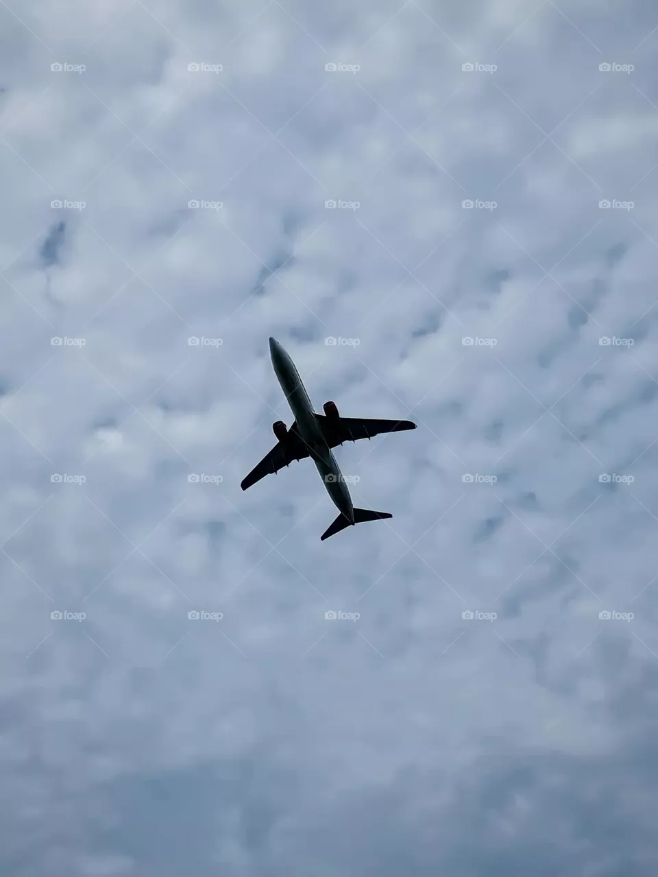 Close-up view of a plane flying in a cloudy sky. Planes with large wings are seen flying high in the sky in low angle view