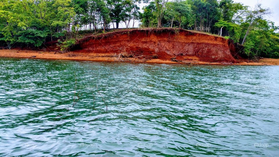 Aguas verdes, matos e barranco de terras vermelhas.