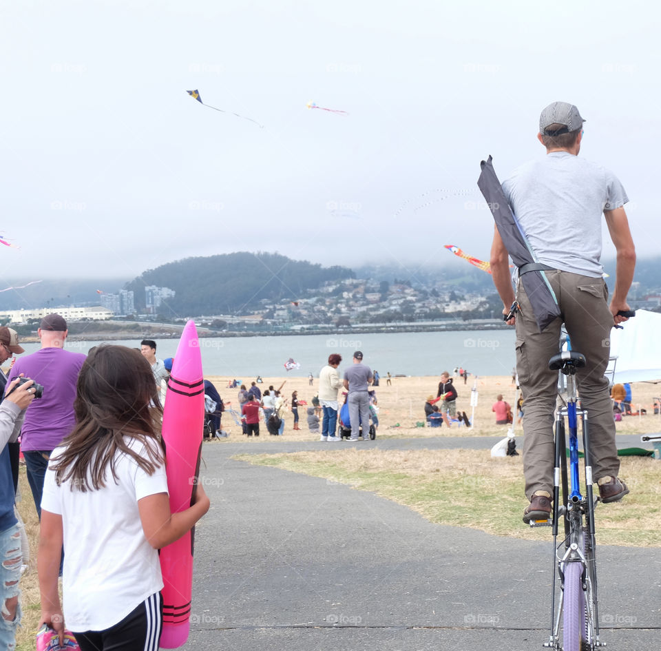 Man cyclists on an unusually high bicycle in park