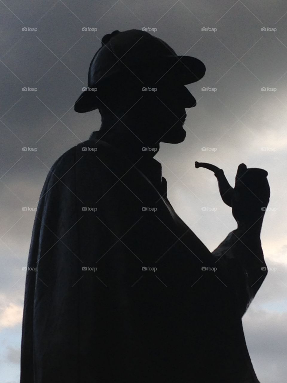Silhouette of Sherlock Holmes statue against sky 