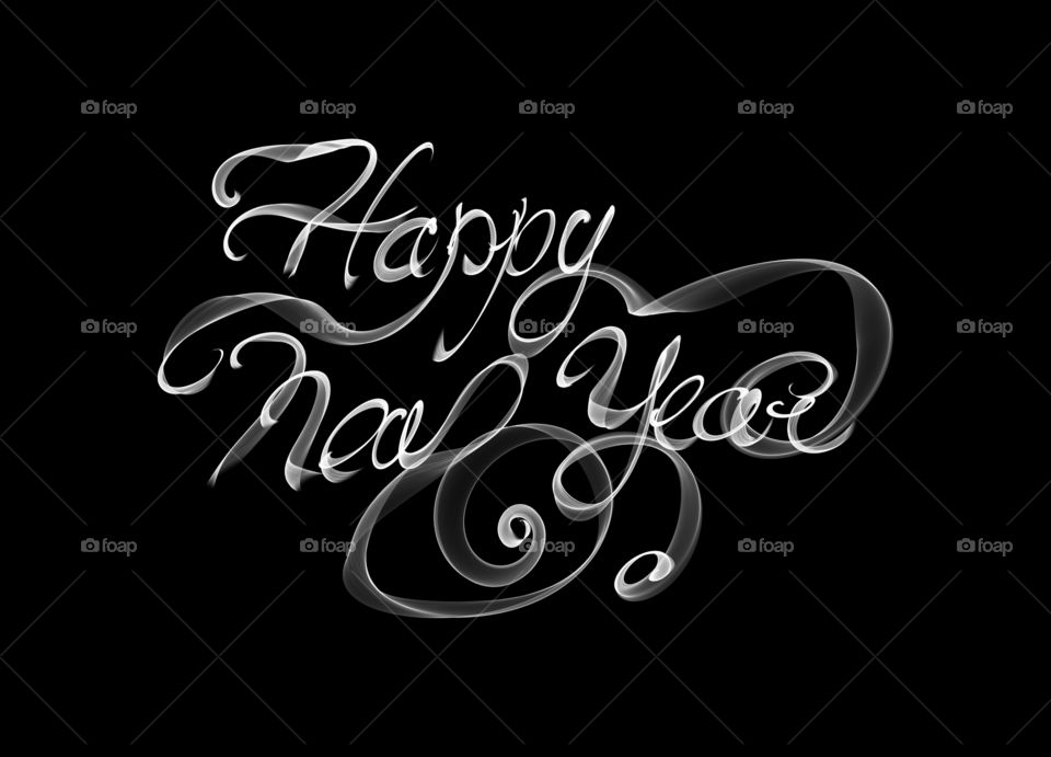 Happy new year lettering written with white flame or smoke on black background