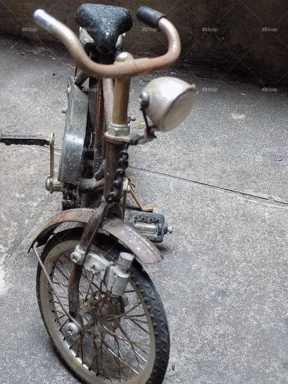 Old, rusty and broken toy bicycle