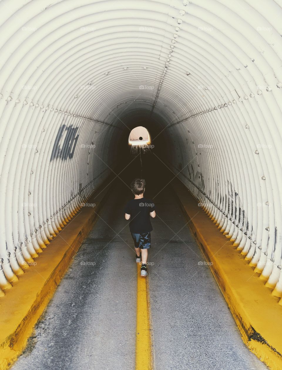 boy walking in tunnel